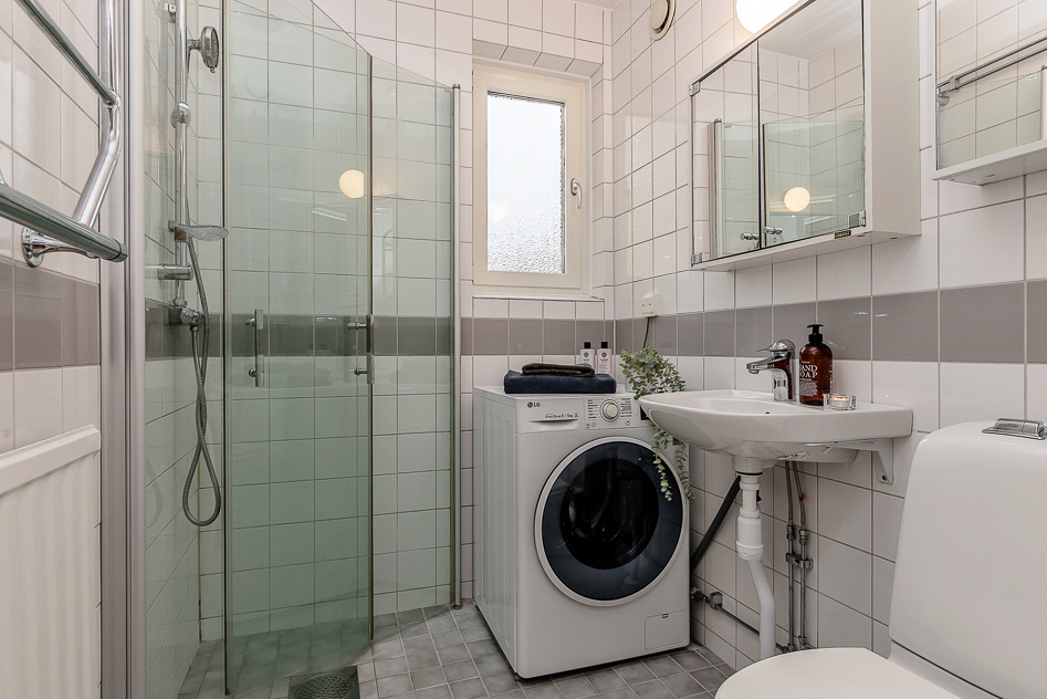 Stambytt badrum med duschhörna och tvättmaskin