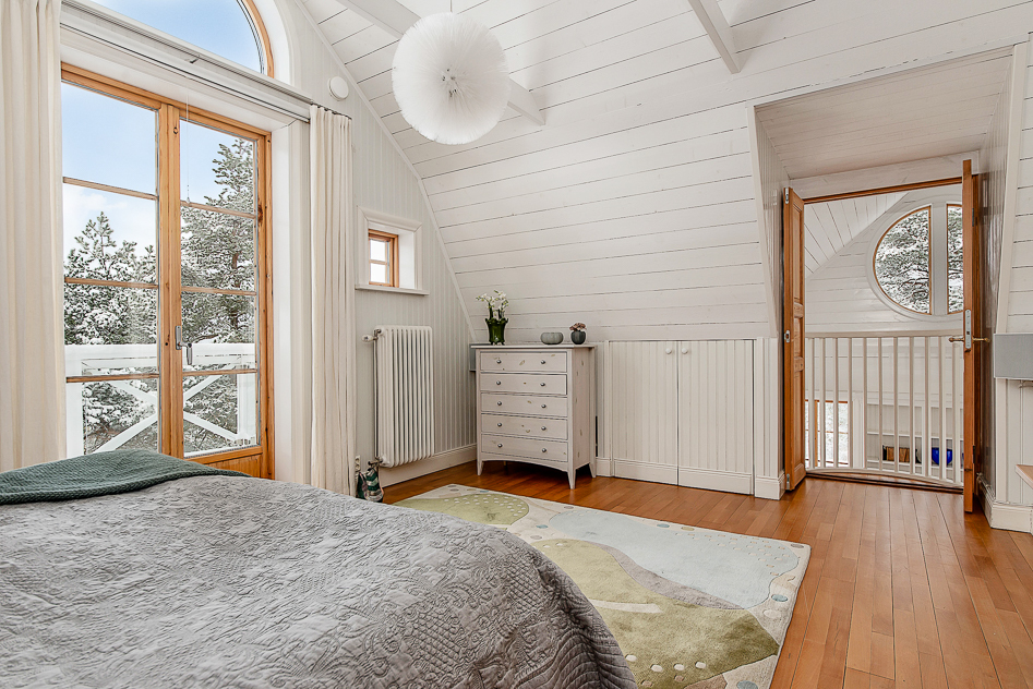 Master bedroom med fransk balkong med vy över vardagsrum och natur